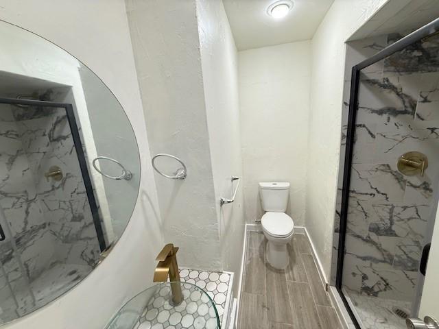 bathroom featuring toilet and walk in shower