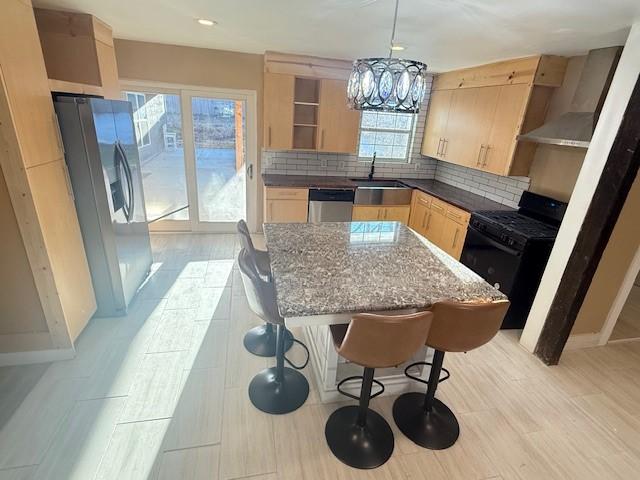 kitchen featuring appliances with stainless steel finishes, pendant lighting, light brown cabinetry, decorative backsplash, and sink