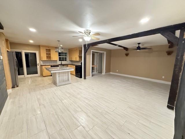 kitchen with a kitchen breakfast bar, decorative backsplash, stainless steel refrigerator, hanging light fixtures, and a kitchen island