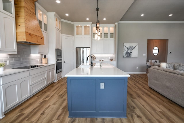 kitchen with tasteful backsplash, crown molding, a center island with sink, pendant lighting, and stainless steel appliances