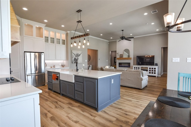 kitchen featuring pendant lighting, sink, crown molding, appliances with stainless steel finishes, and white cabinetry