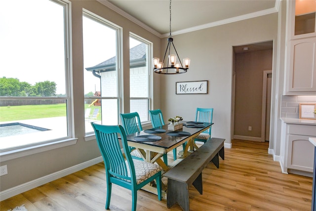 dining space with baseboards, light wood-style flooring, and crown molding