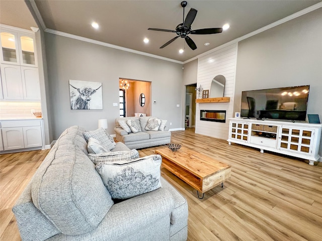 living area with a fireplace, recessed lighting, light wood-style flooring, ornamental molding, and a ceiling fan