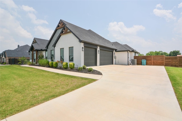 view of front of house with central AC, a front yard, and a garage