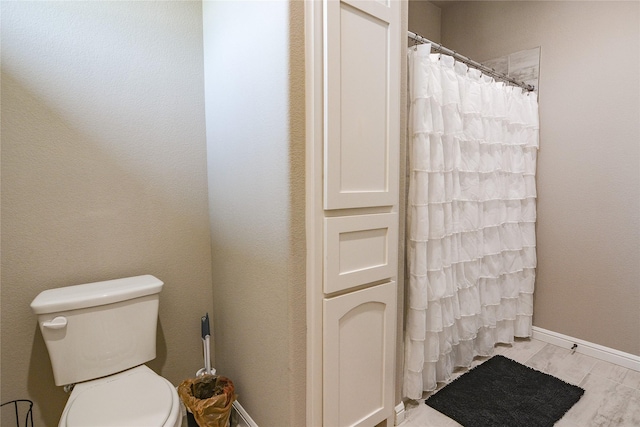 full bath with baseboards, toilet, and wood finished floors