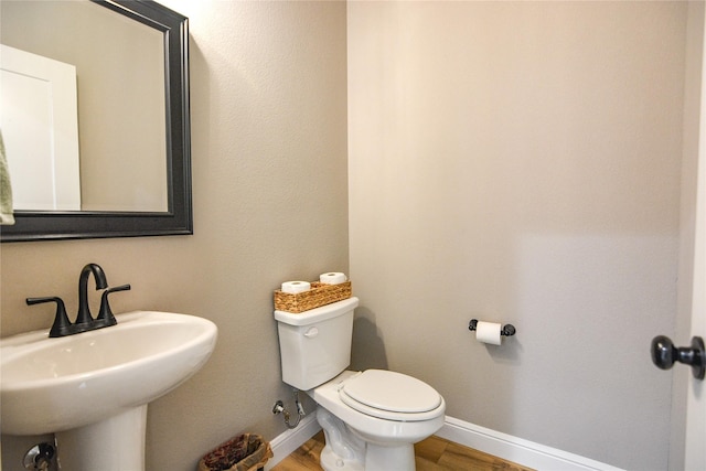 bathroom with hardwood / wood-style flooring, toilet, and sink