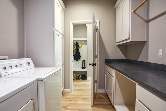 laundry room with cabinets, light hardwood / wood-style flooring, and washing machine and clothes dryer