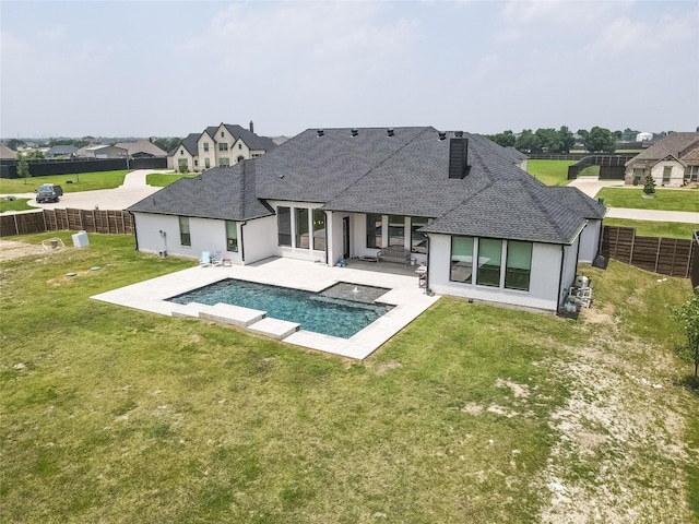 back of house with a fenced in pool, a lawn, and a patio