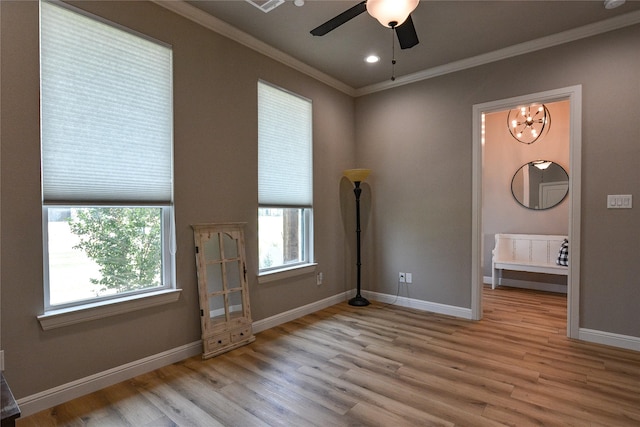 interior space featuring ceiling fan with notable chandelier, ornamental molding, and light wood-type flooring