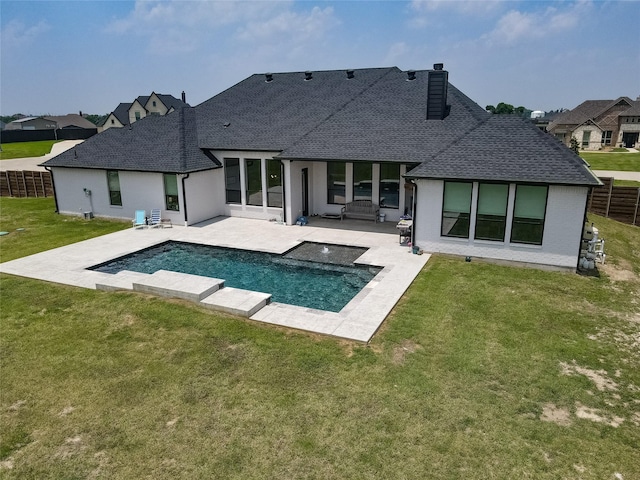 rear view of house with a yard, roof with shingles, a patio, and fence