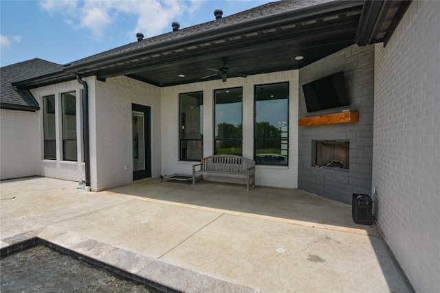 view of patio / terrace featuring a large fireplace and ceiling fan