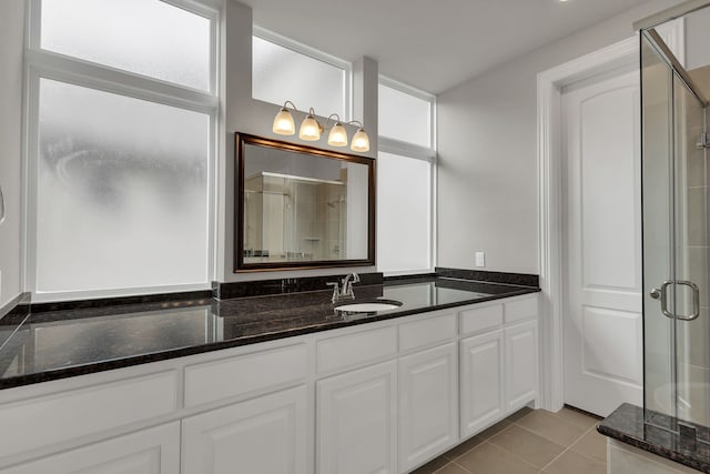 bathroom featuring tile patterned floors, vanity, and a shower with door