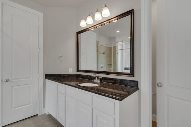 bathroom with tile patterned flooring, vanity, and a shower with shower door