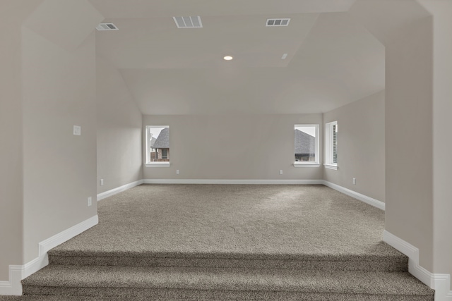 stairs with carpet flooring, a wealth of natural light, and lofted ceiling