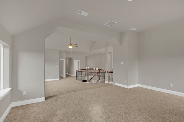 spare room with ceiling fan, light colored carpet, and vaulted ceiling