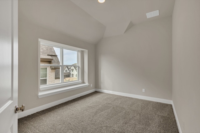 spare room featuring carpet and vaulted ceiling