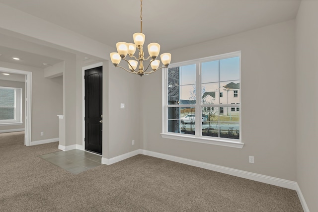 empty room with carpet and a chandelier