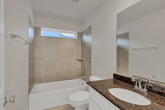 full bathroom with tile patterned flooring, vanity, tiled shower / bath combo, and toilet