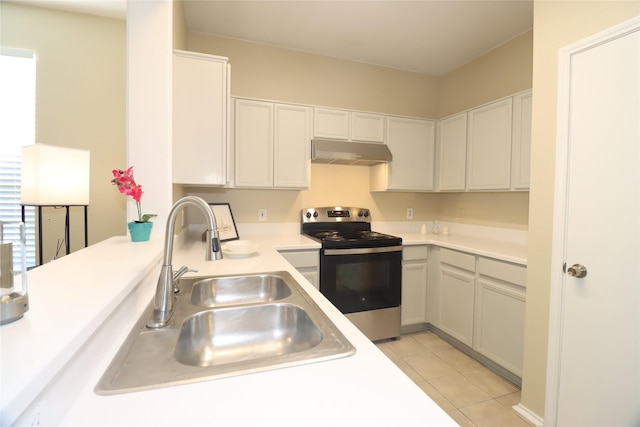 kitchen with electric range, light tile patterned floors, and sink