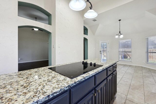 kitchen with pendant lighting, blue cabinetry, light stone counters, black electric stovetop, and ceiling fan with notable chandelier