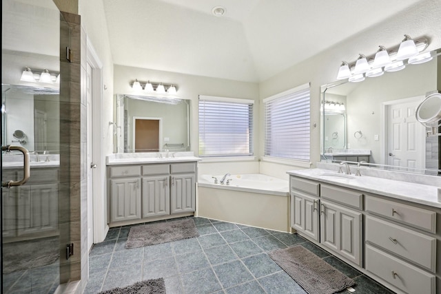 bathroom with vanity, independent shower and bath, and vaulted ceiling