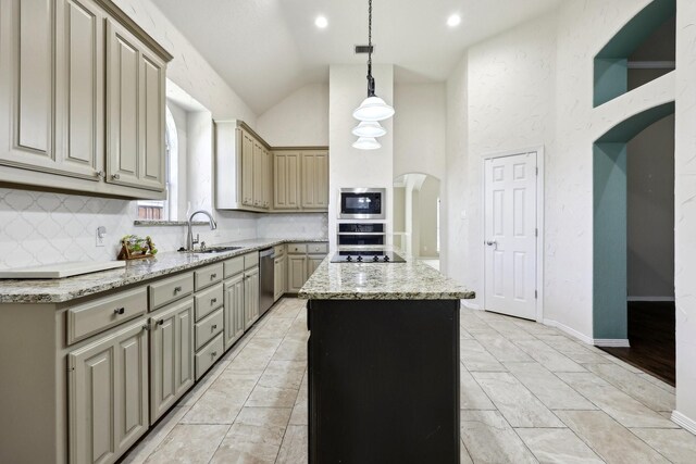 kitchen featuring a kitchen island, appliances with stainless steel finishes, sink, hanging light fixtures, and light stone counters