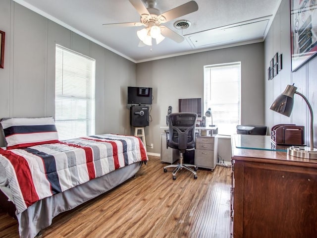 bedroom featuring crown molding, light hardwood / wood-style flooring, and ceiling fan