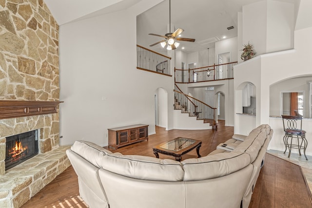 living room with a fireplace, hardwood / wood-style floors, high vaulted ceiling, and ceiling fan