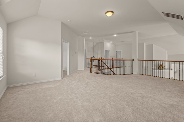 carpeted spare room featuring vaulted ceiling