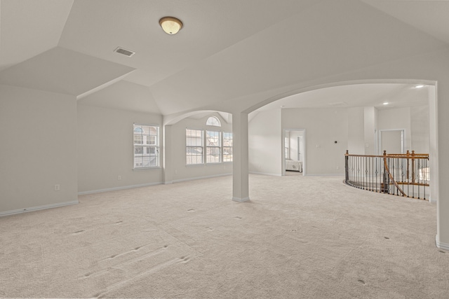 spare room with light colored carpet and lofted ceiling