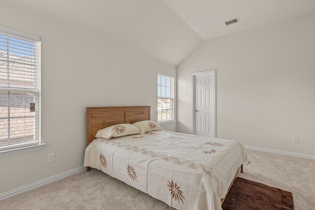 bedroom with multiple windows, light colored carpet, and lofted ceiling