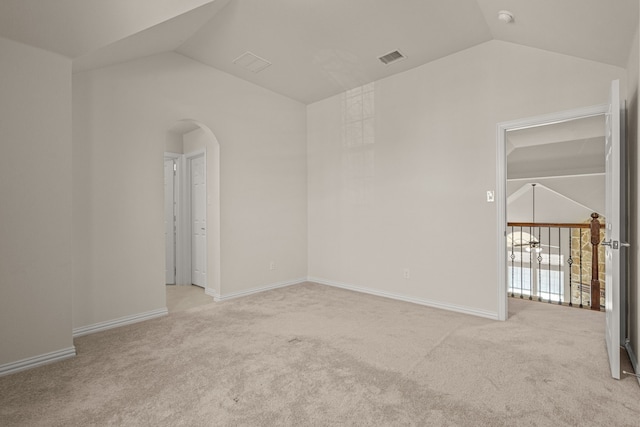 unfurnished room with light carpet and vaulted ceiling