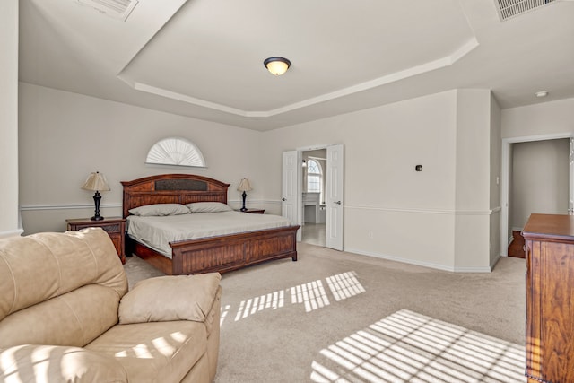 bedroom with a tray ceiling and light colored carpet