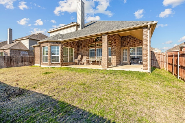 back of house with a patio and a lawn