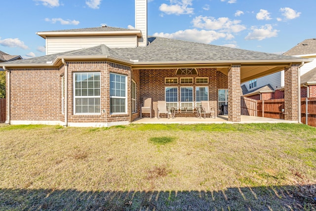 rear view of house featuring a patio and a lawn