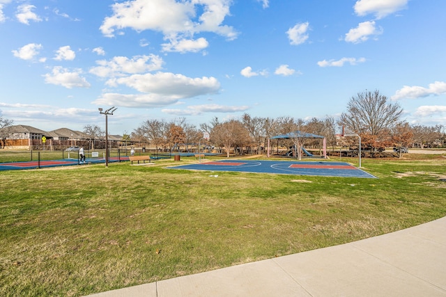 view of sport court with a lawn, tennis court, and a playground