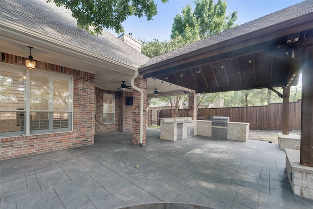 view of patio / terrace with grilling area, ceiling fan, and exterior kitchen