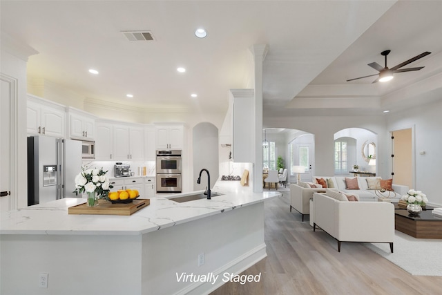 kitchen with sink, ceiling fan, light stone counters, white cabinetry, and stainless steel appliances