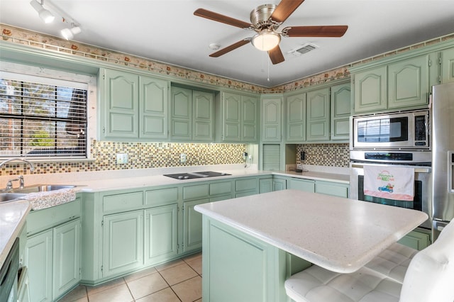 kitchen featuring backsplash, light tile patterned flooring, sink, and stainless steel appliances