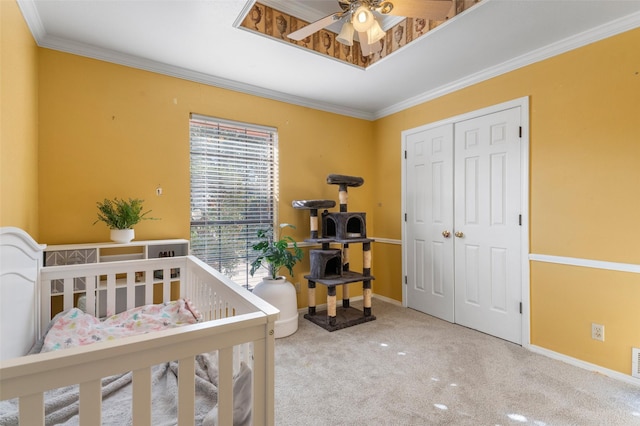 bedroom with carpet, ceiling fan, crown molding, and a closet