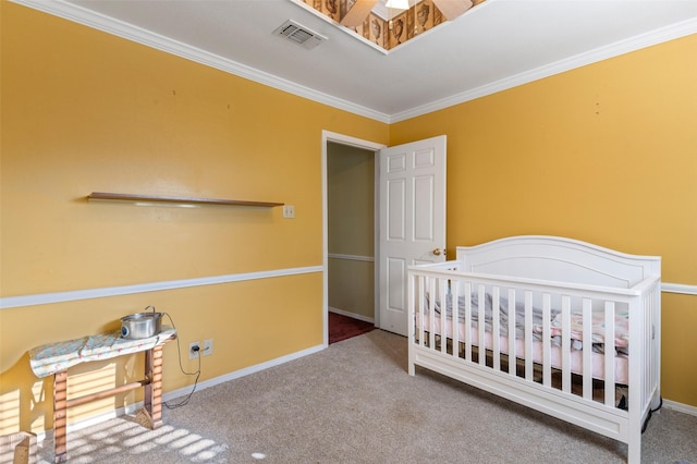 bedroom with a crib, carpet, and crown molding