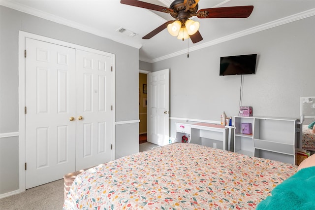 carpeted bedroom featuring ceiling fan, ornamental molding, and a closet