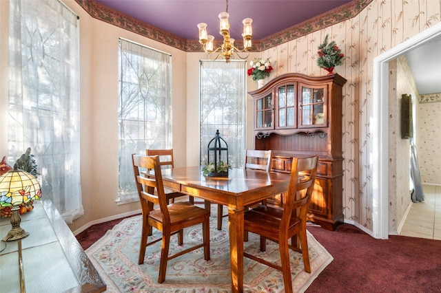 carpeted dining area with a notable chandelier