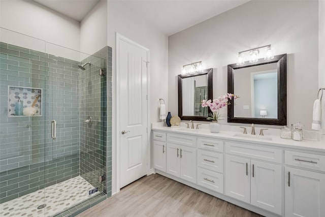 bathroom featuring hardwood / wood-style floors, vanity, and a shower with door