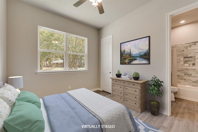 bedroom featuring light hardwood / wood-style floors, ensuite bath, and ceiling fan