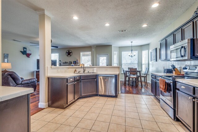 kitchen featuring pendant lighting, stainless steel appliances, light tile patterned floors, and sink