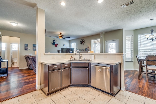 kitchen with light tile patterned floors, ceiling fan with notable chandelier, stainless steel dishwasher, and sink