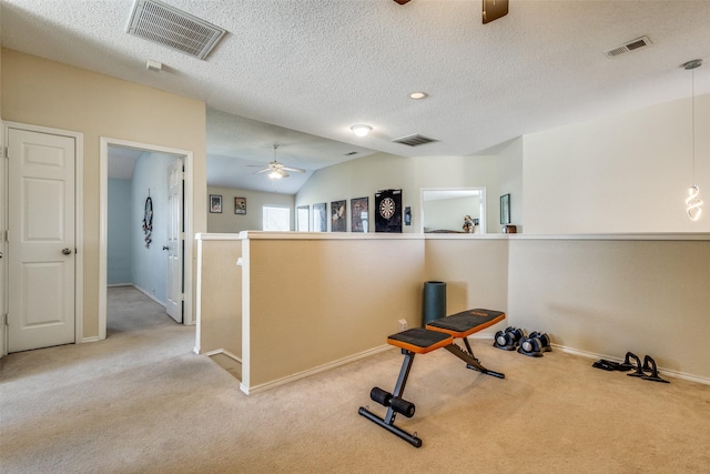 exercise area featuring a textured ceiling, ceiling fan, light carpet, and lofted ceiling