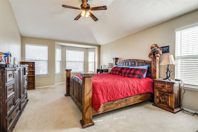 bedroom featuring ceiling fan, lofted ceiling, and multiple windows