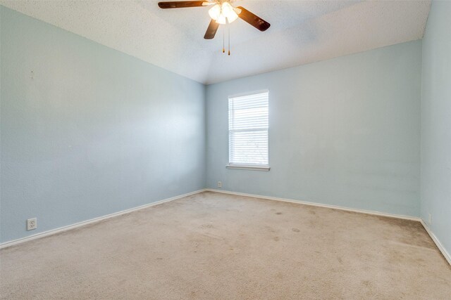 carpeted empty room featuring a textured ceiling, ceiling fan, and lofted ceiling